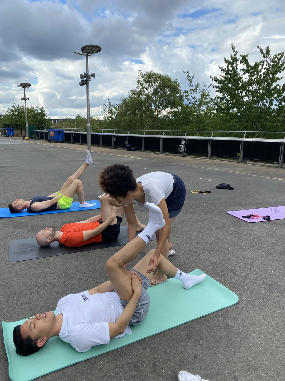Rosa supporting participants in an outdoor group stretch
